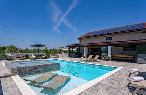 Oklaj Villa | 4 en-suite bedrooms, two finnish saunas, heated pool with Whirlpool, deck chairs in shallow area, natural surroundings