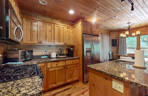 Cherry Log Cabin | Creek Cabin with fenced yard, screened in patio and hot tub