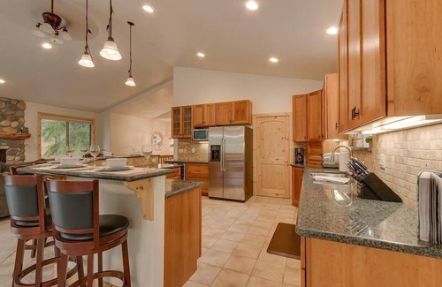Tahoe Island House | Enjoy the tree-lined yard, spacious deck, and hot tub!
