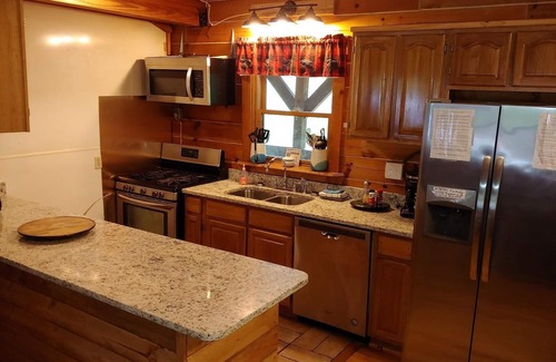 Zoe Cabin | Large Log home, private pond with dock, canoe, pool table, hot tub & internet.