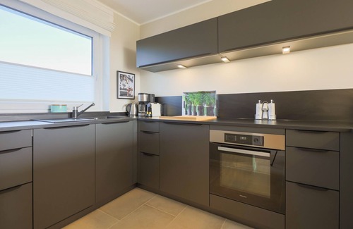 Rantum House | The walls are painted in a warm beige and decorated with cool pictures.