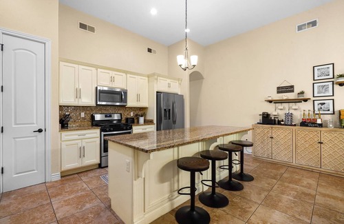 Biggs Field House | This is a true retreat in El Paso with a sparkling pool (w heater), hot tub, and full outdoor entertaining area with a 55" smart TV, tiki bar, and grill.