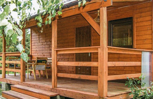 Nowecin House | This small wooden cottage has a covered terrace with garden furniture.