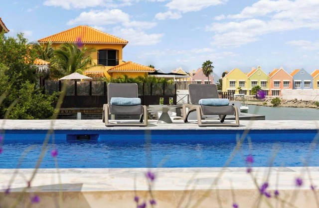 Water villa with terrace, SUP boards, barbecue, and access to a shared swimming pool.