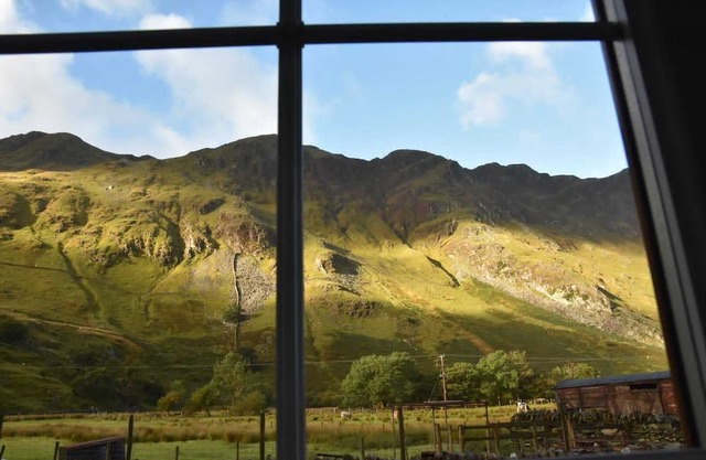 Traditional Welsh stone cottage nestled within the iconic Llanberis Pass.